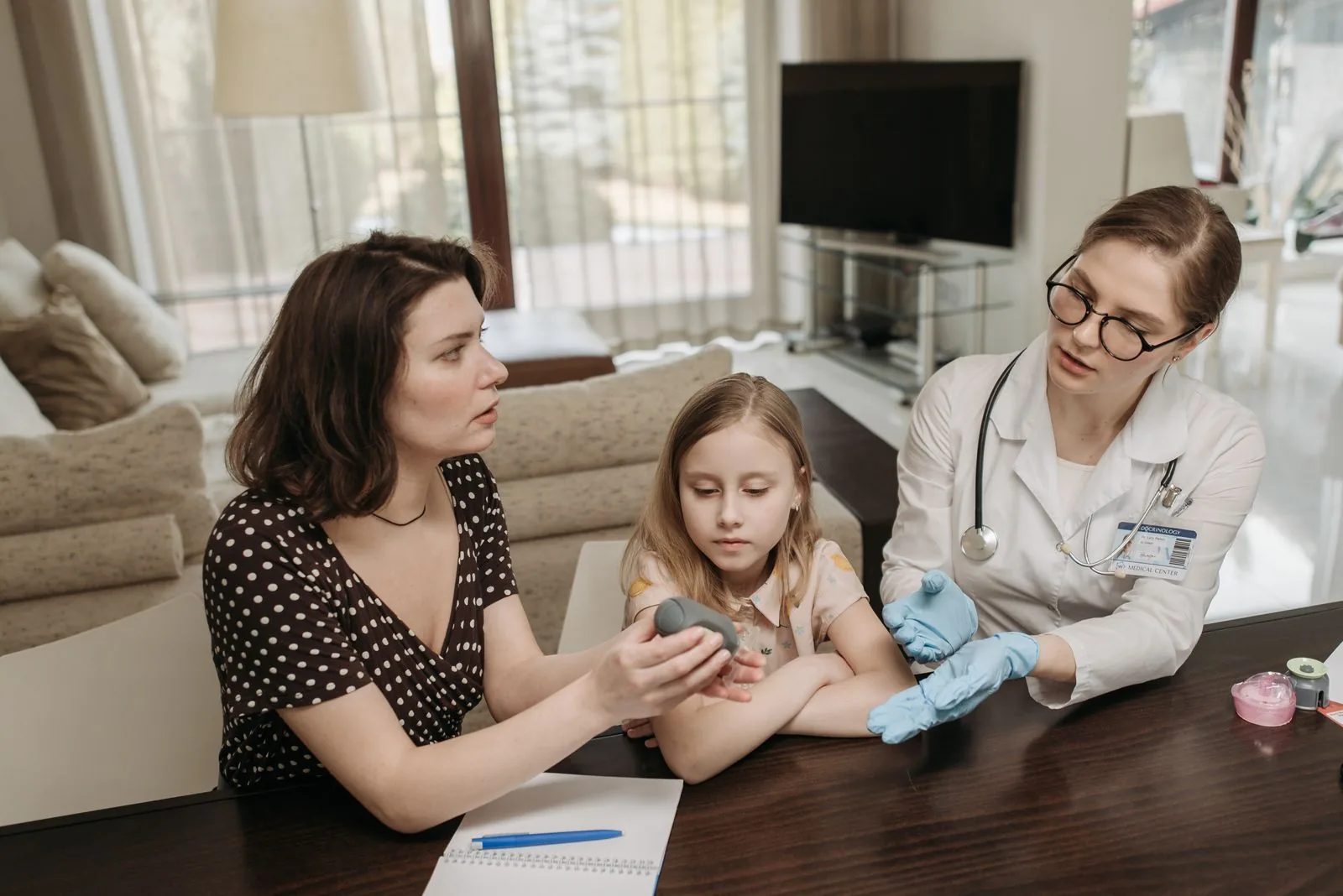 Mãe e filha conversando com médica em casa